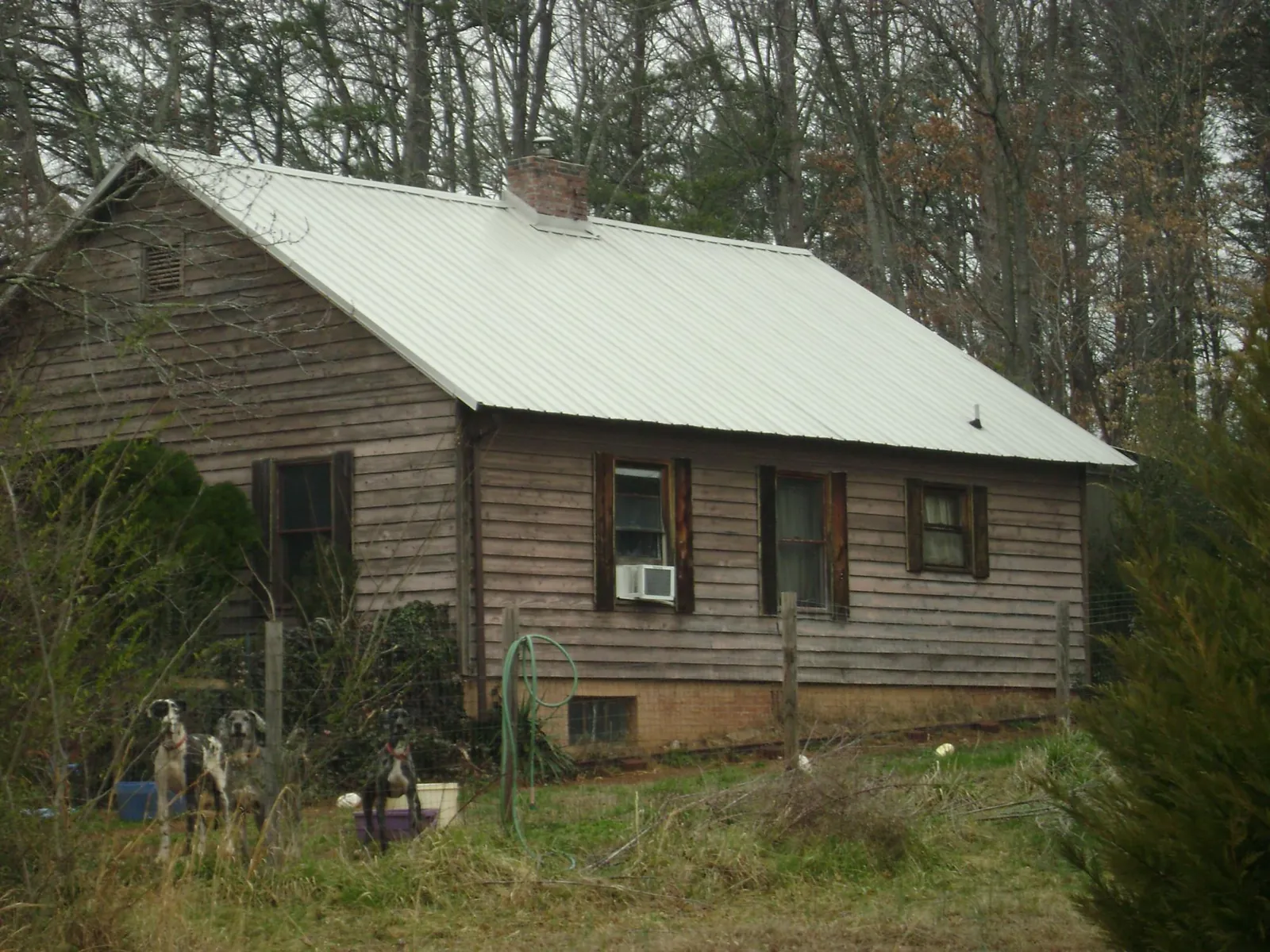 White metal roof on an old wood sided farmhouse, from a Asphalt Shingle Roof Repair job in Langston